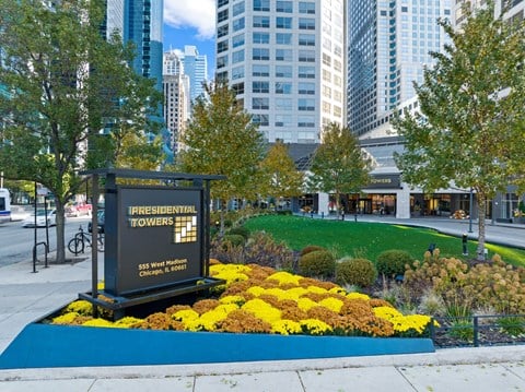a commemorative sign in front of a park with flowers at Presidential Towers, Illinois, 60661
